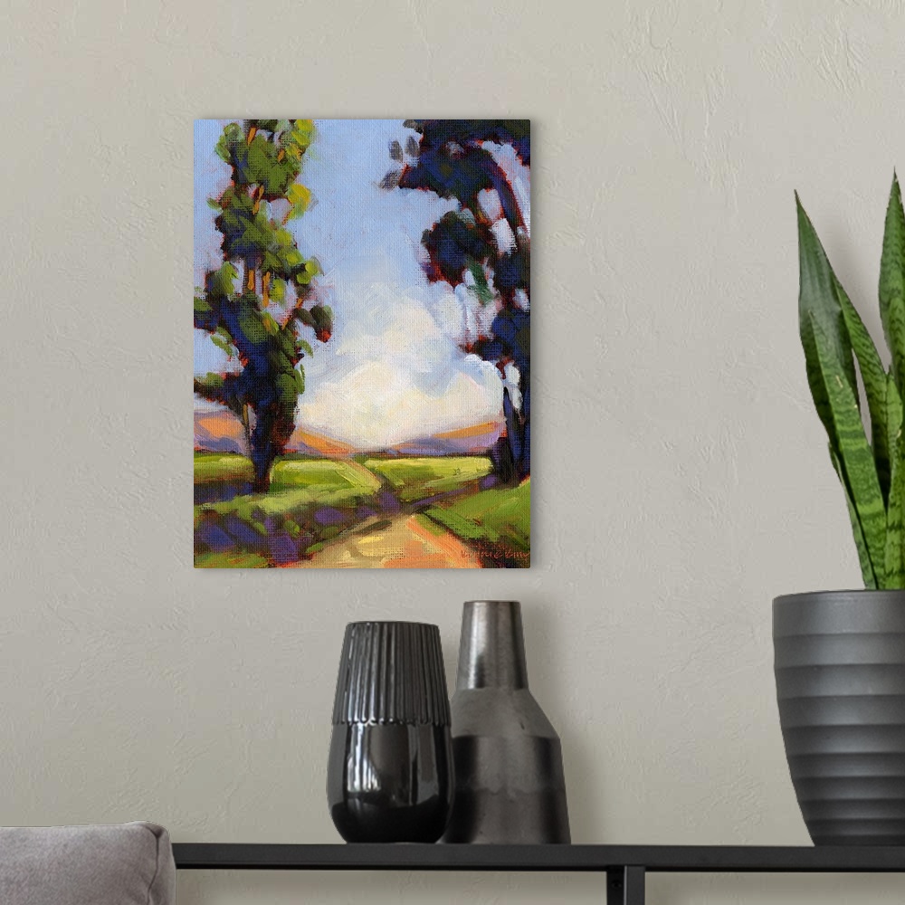 A modern room featuring Vertical painting of a country road framed by two large trees.