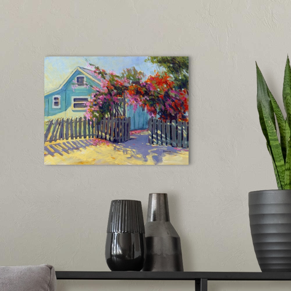 A modern room featuring Contemporary painting of a blue house with vibrant red flowers in a fenced archway.