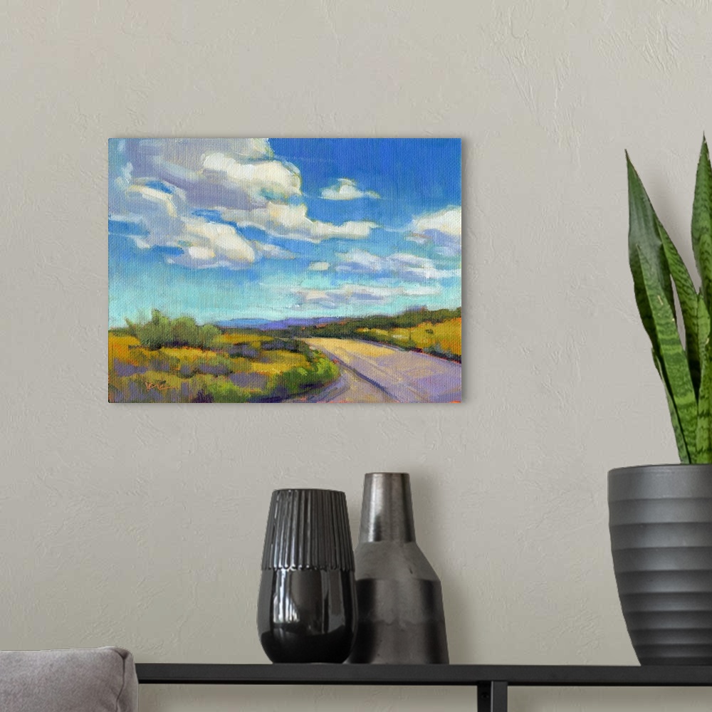 A modern room featuring Contemporary landscape painting of a road going through green fields with clouds and a blue sky a...