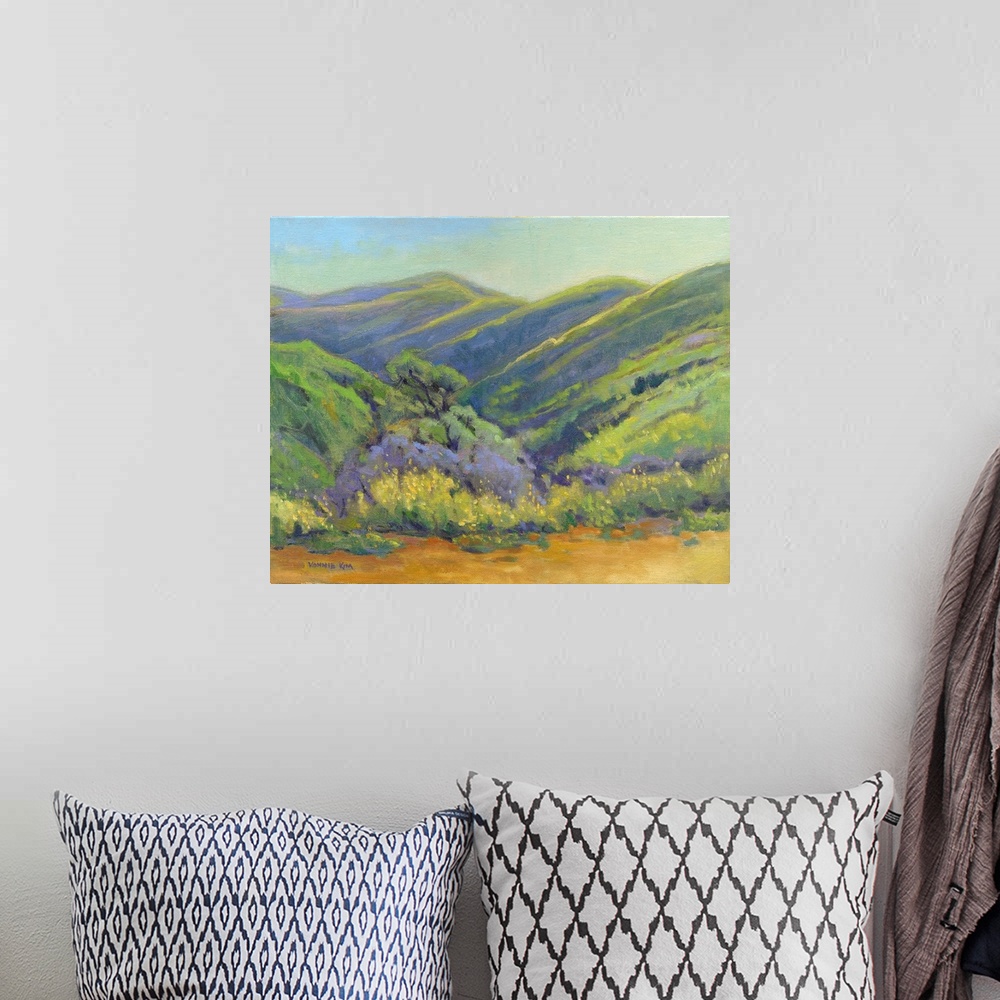 A bohemian room featuring A contemporary painting of a row of trees and rolling hills in vibrant colors.