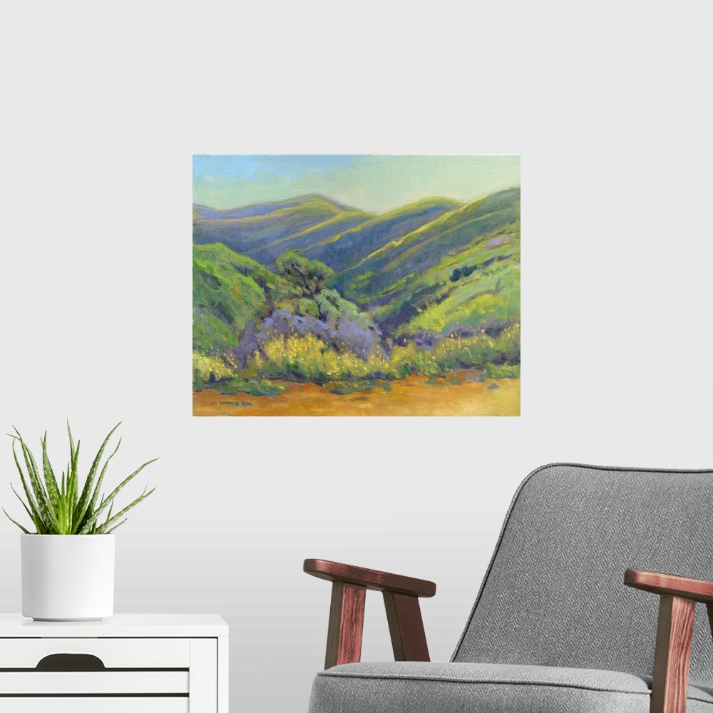 A modern room featuring A contemporary painting of a row of trees and rolling hills in vibrant colors.