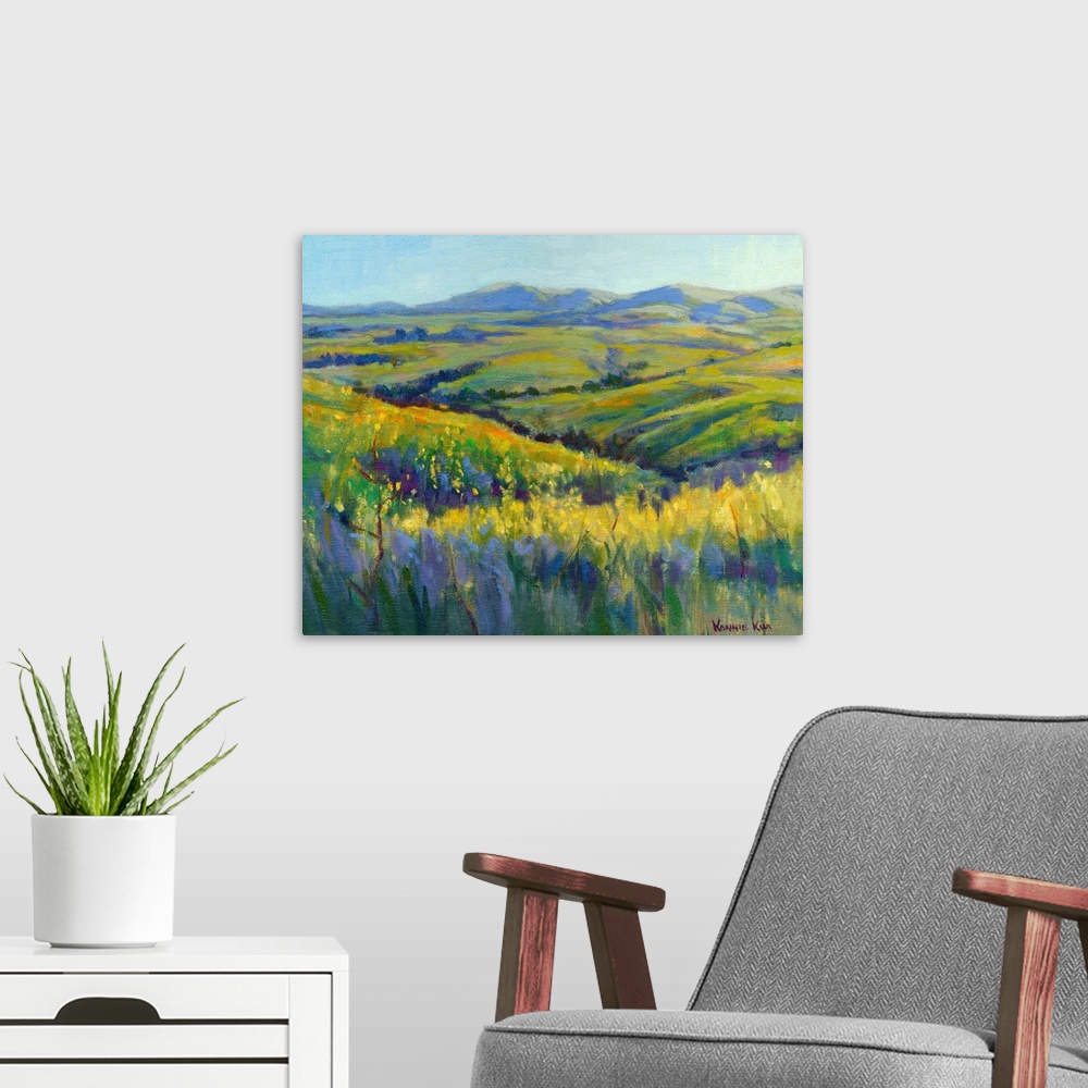 A modern room featuring A contemporary painting of a row of wild flowers and rolling hills in vibrant colors.