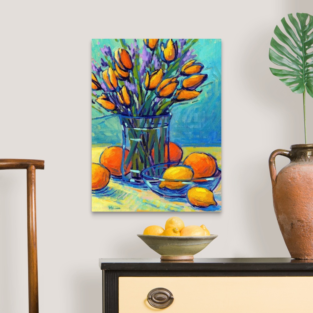 A traditional room featuring A vertical contemporary painting of a glass vase of tulips with oranges and lemons.