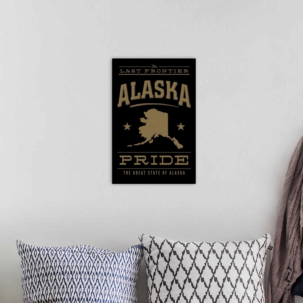 A bohemian room featuring The Alaska state outline on black with gold text.
