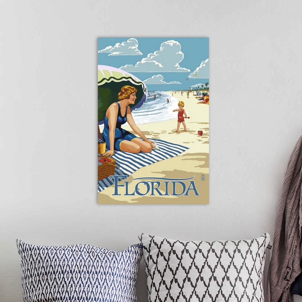 A bohemian room featuring Retro stylized art poster of a beach scene, with a woman sitting on a blanket under a an umbrella.