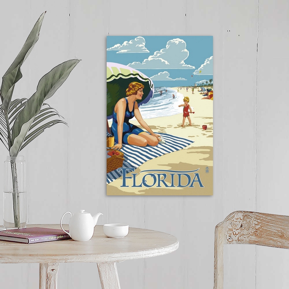 A farmhouse room featuring Retro stylized art poster of a beach scene, with a woman sitting on a blanket under a an umbrella.