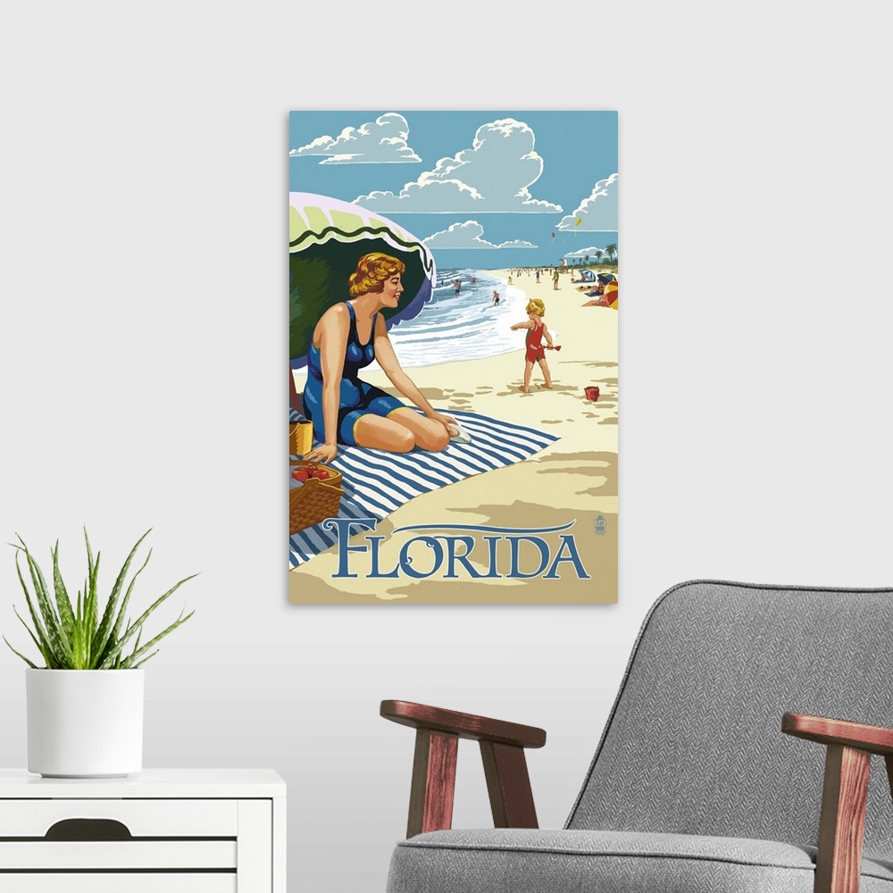 A modern room featuring Retro stylized art poster of a beach scene, with a woman sitting on a blanket under a an umbrella.