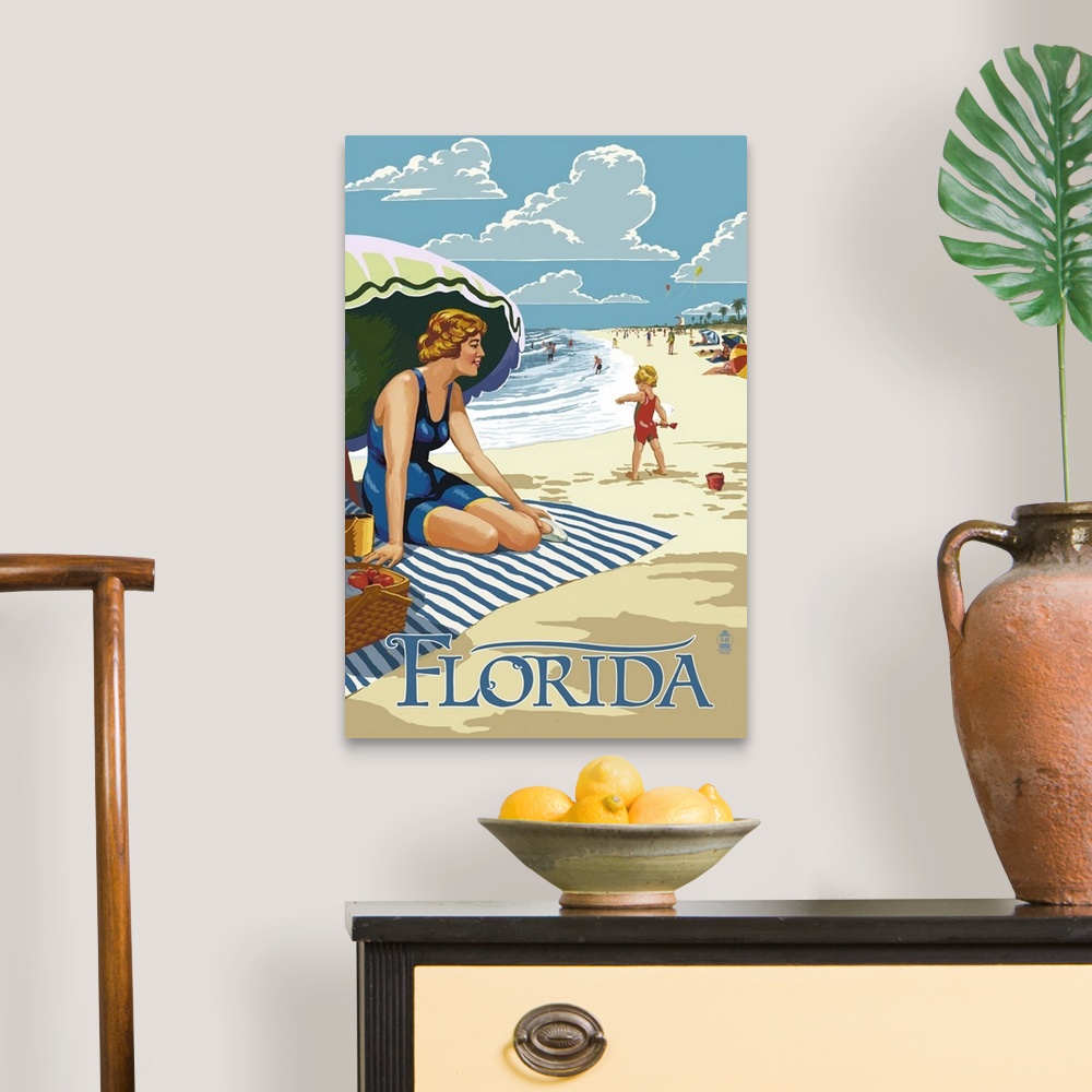A traditional room featuring Retro stylized art poster of a beach scene, with a woman sitting on a blanket under a an umbrella.