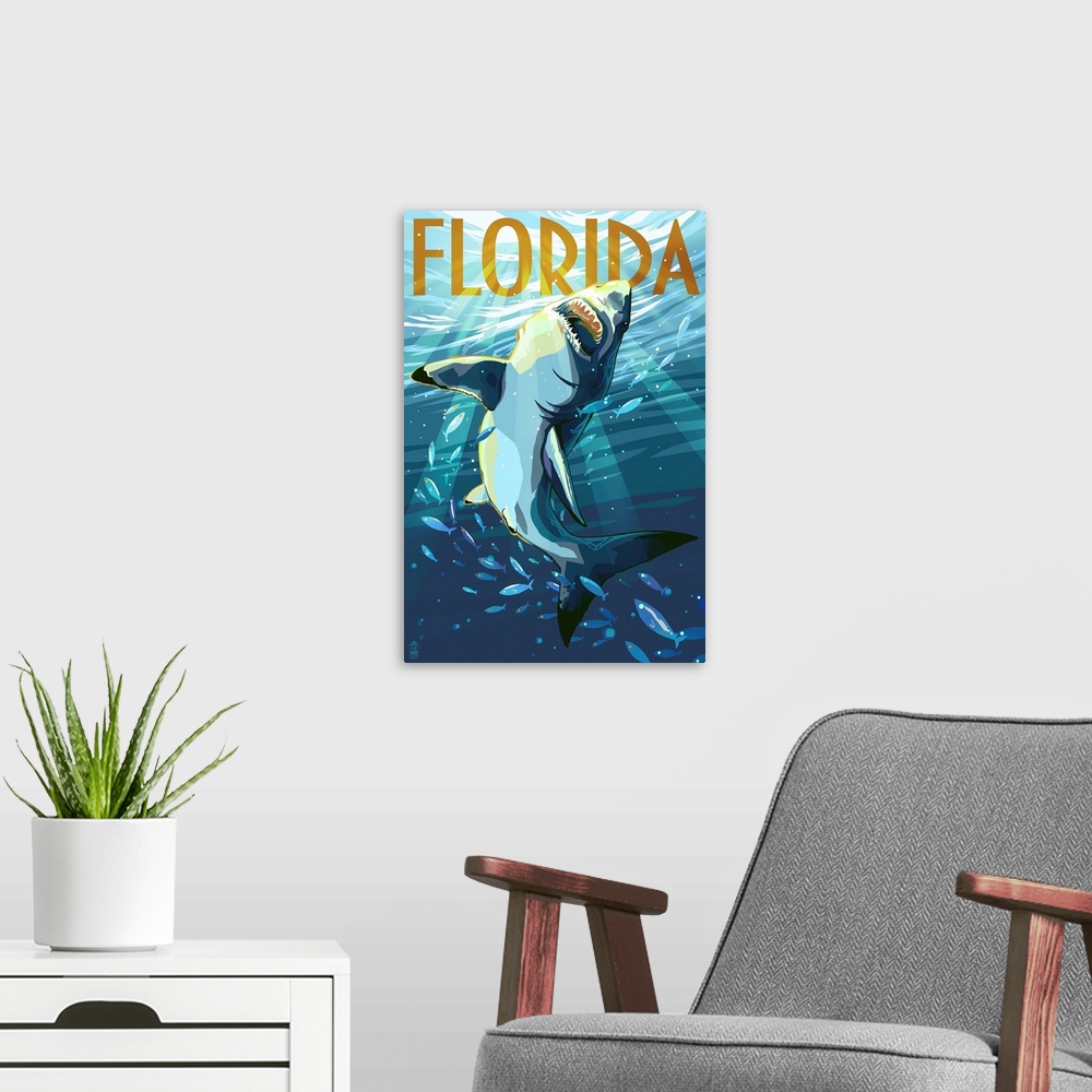 A modern room featuring A stylized art poster of a great white shark writhing underwater through a school of fish.