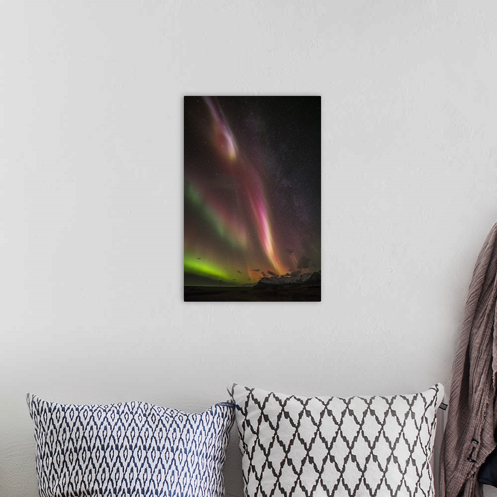 A bohemian room featuring Photograph of the Aurora Borealis illuminated in a starry night sky.