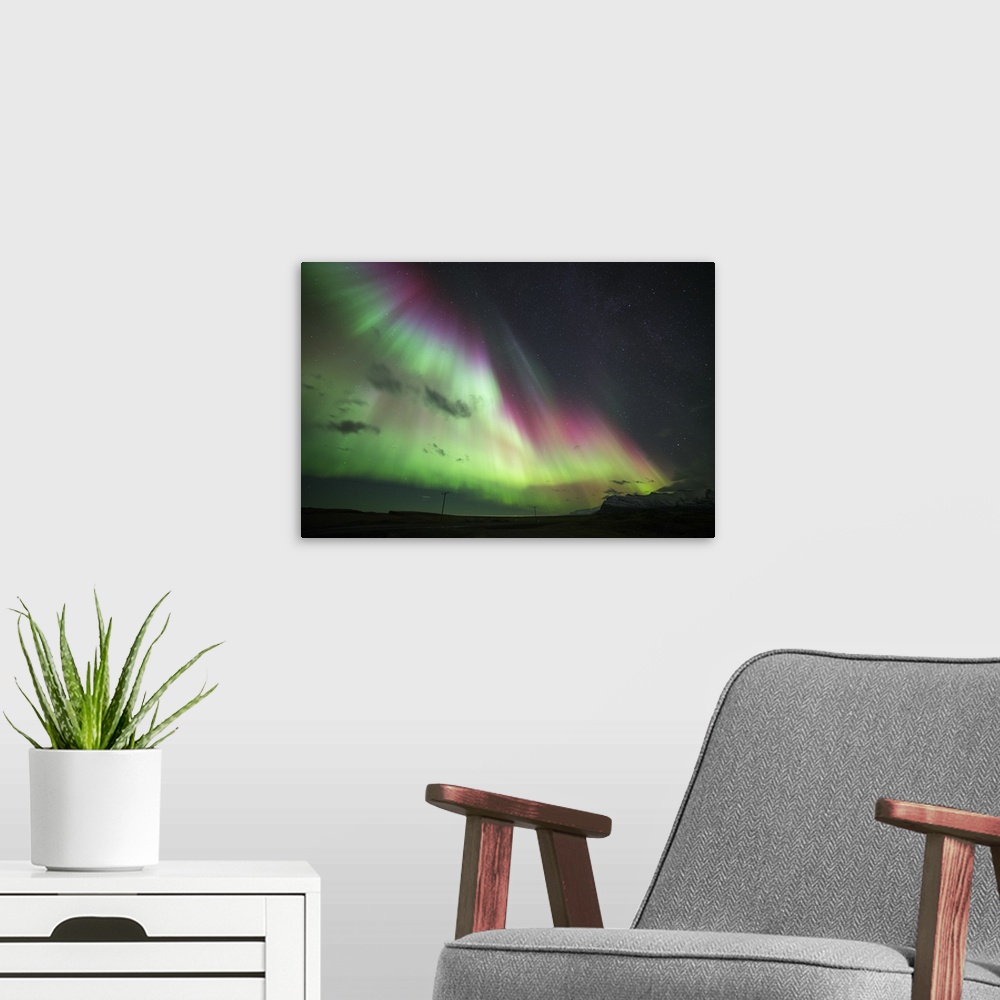 A modern room featuring Photograph of the Aurora Borealis illuminated in a starry night sky.