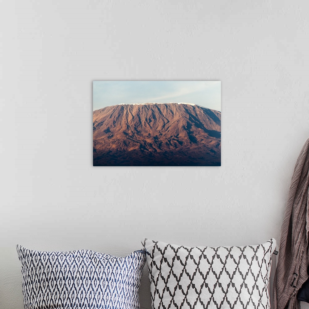 A bohemian room featuring Photograph of a mountain in Africa half cast in shadow from the setting sun.
