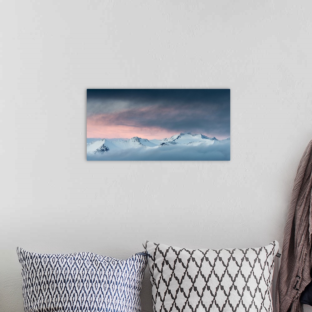 A bohemian room featuring Snow-covered mountainous landscape with a glowing orange sky above.
