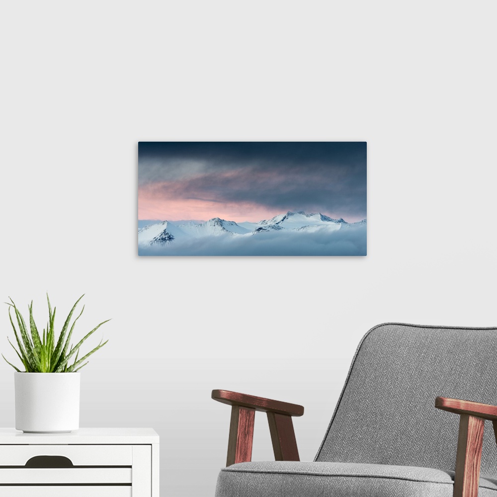 A modern room featuring Snow-covered mountainous landscape with a glowing orange sky above.