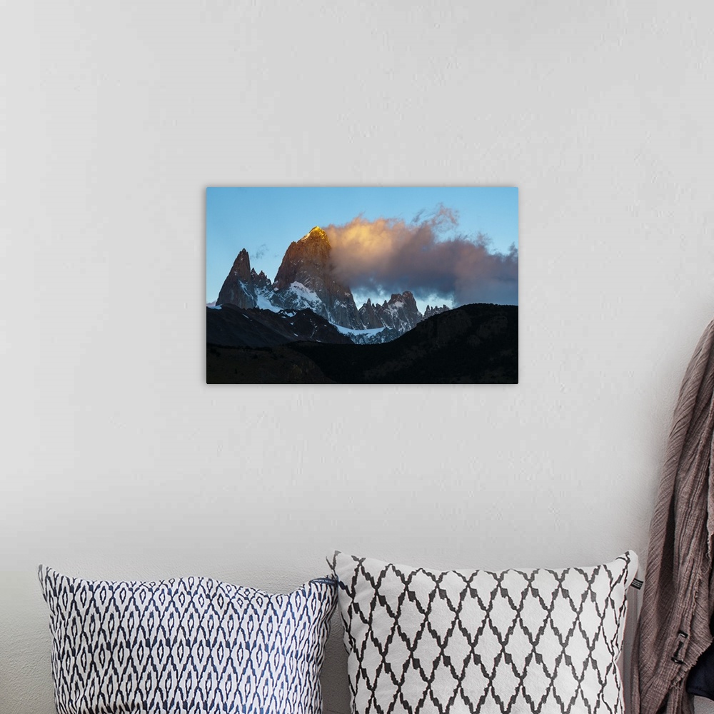 A bohemian room featuring Photograph of golden mountain spires in South America illuminated by the setting sun.