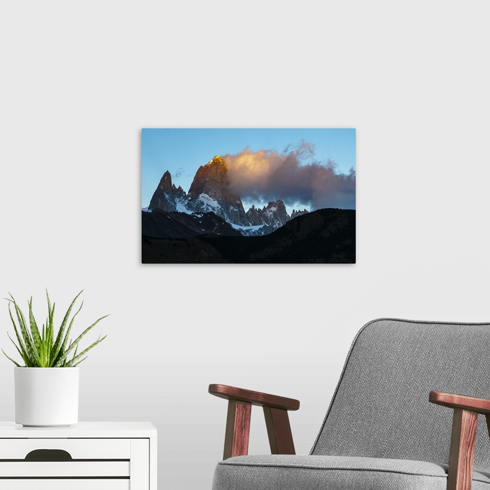 A modern room featuring Photograph of golden mountain spires in South America illuminated by the setting sun.