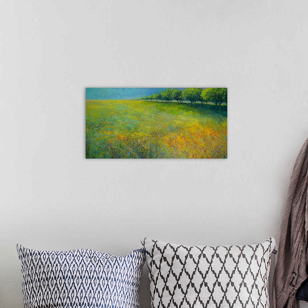 A bohemian room featuring Brightly colored contemporary artwork of a landscape of trees bordering a field of flowers.