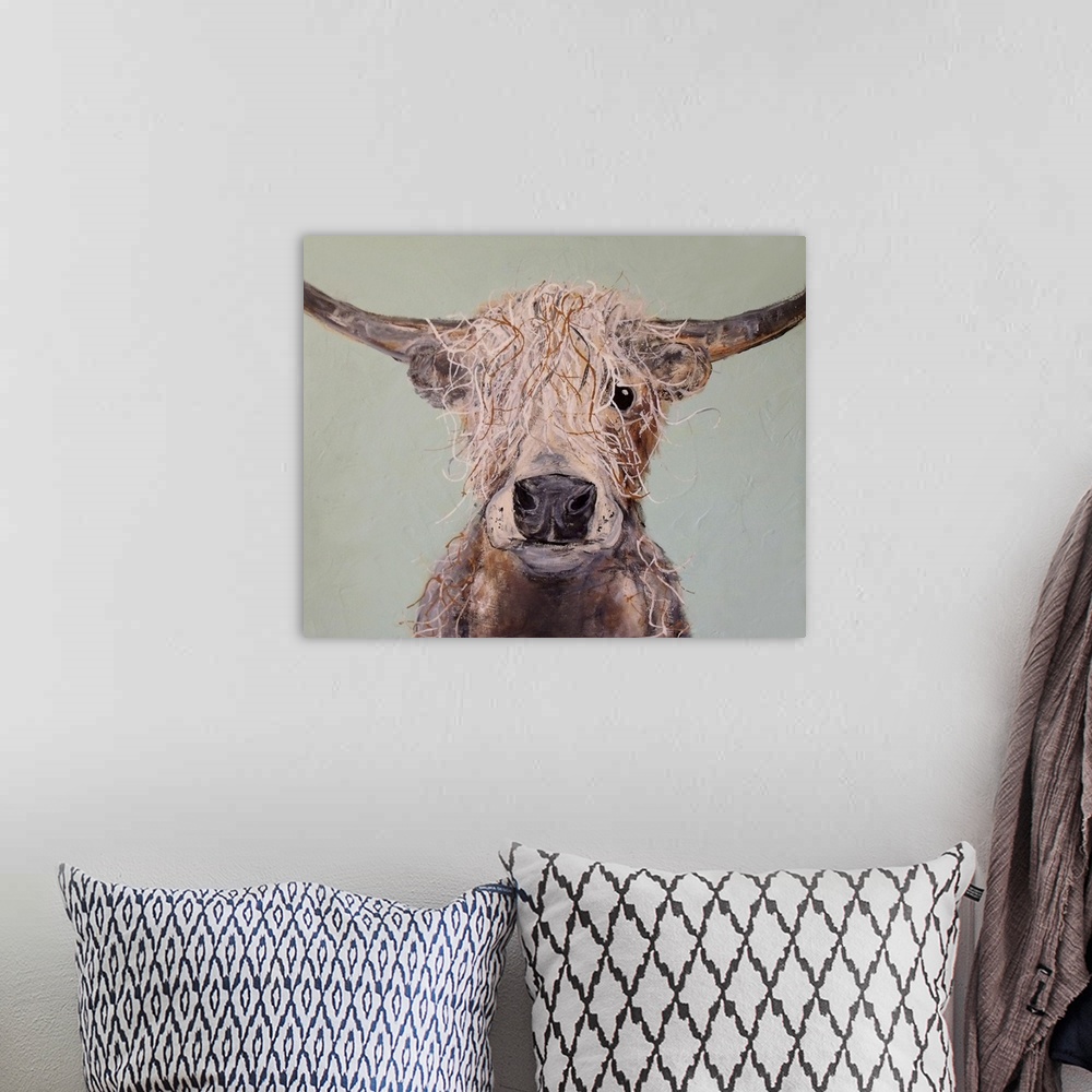 A bohemian room featuring Portrait of a cow with shaggy hair and long horns.