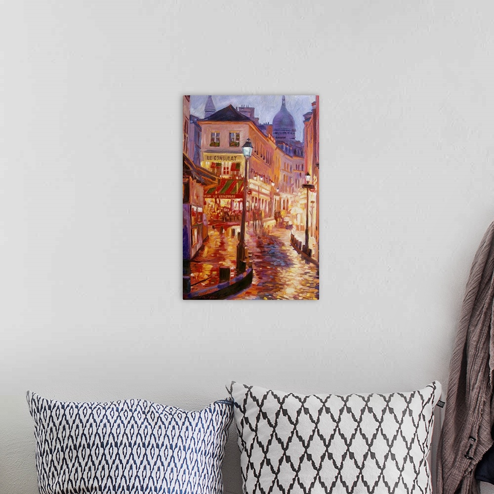 A bohemian room featuring Painting of a European city street glowing from the street lights at night.