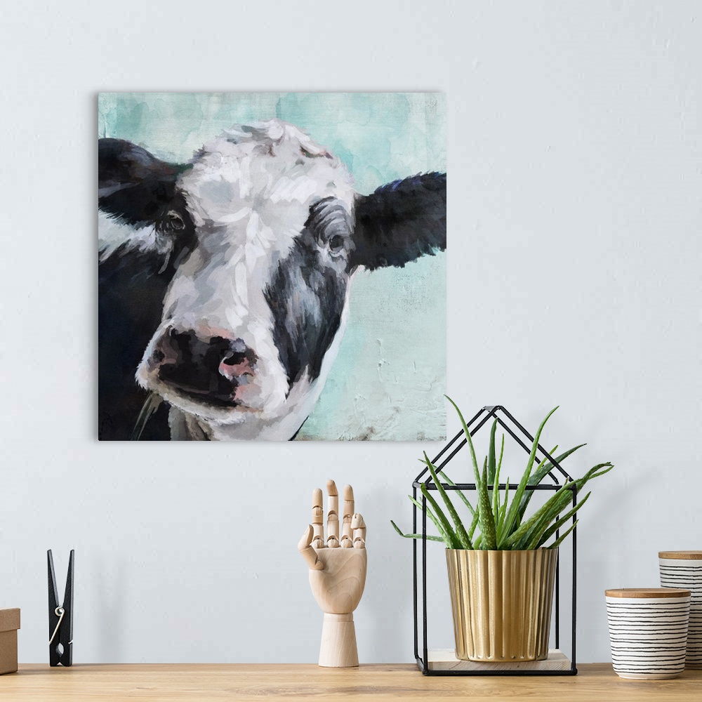 A bohemian room featuring A contemporary painting of a black and white cow on a pale blue background.