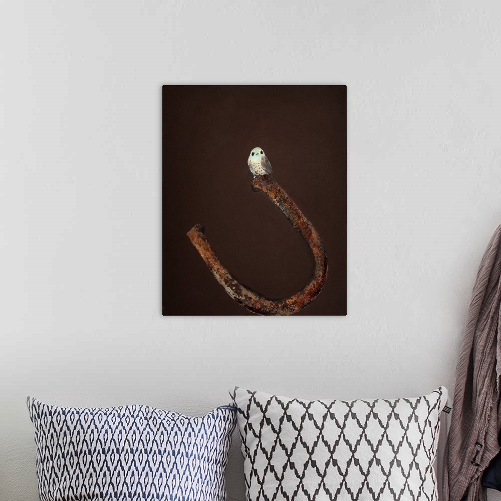 A bohemian room featuring Painting of a small bird perched on the end of a horseshoe.