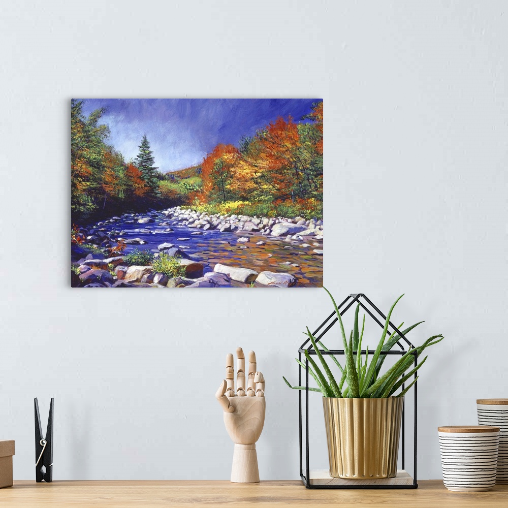 A bohemian room featuring Painting of a river lined with rocks and trees turning fall colors.