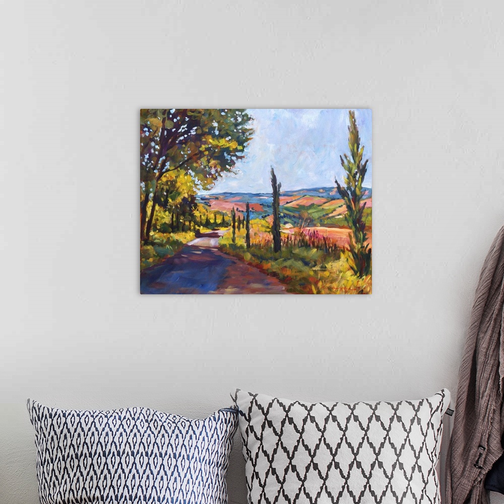 A bohemian room featuring Painting of a road through the Tuscan countryside.