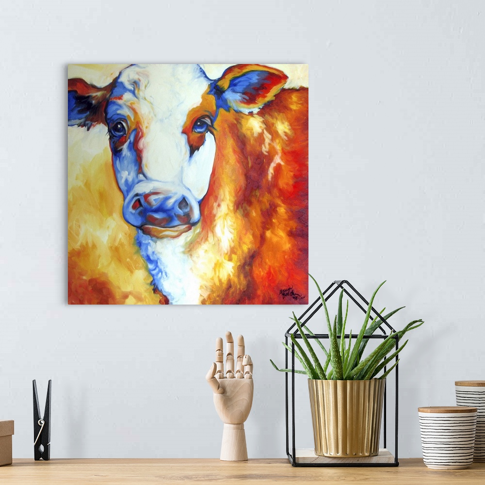 A bohemian room featuring Contemporary painting of a cow made with orange, yellow, red, white, and blue hues on a square ba...