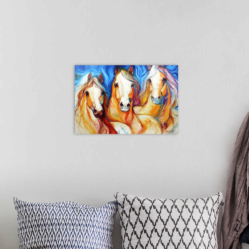A bohemian room featuring Contemporary painting of three light brown horses with flowing manes on a blue background.