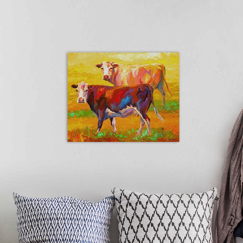 A bohemian room featuring A pair of cows looking forward on a brightly-painted landscape.