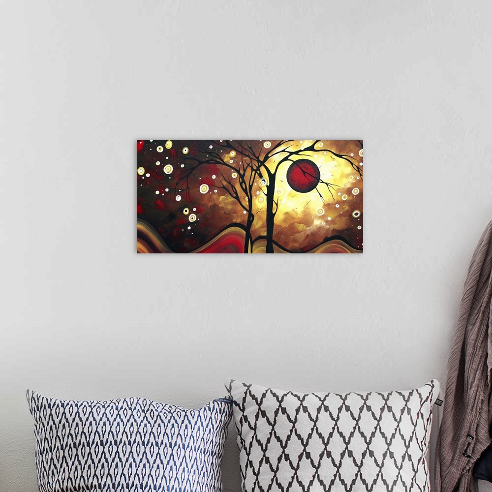 A bohemian room featuring Abstract artwork that has a silhouette of two trees with a deep red sun behind them and white cir...