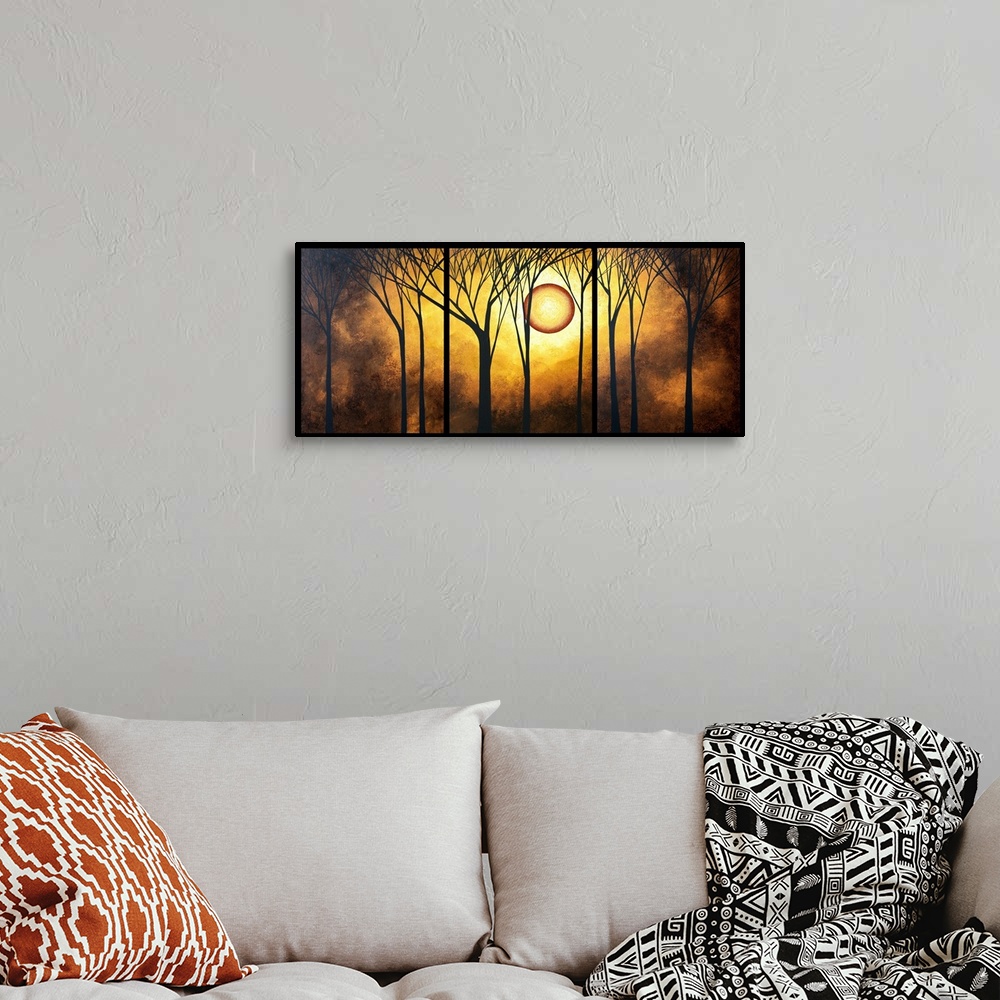 A bohemian room featuring A piece of contemporary artwork that has silhouettes of trees in front of a bright golden sun and...