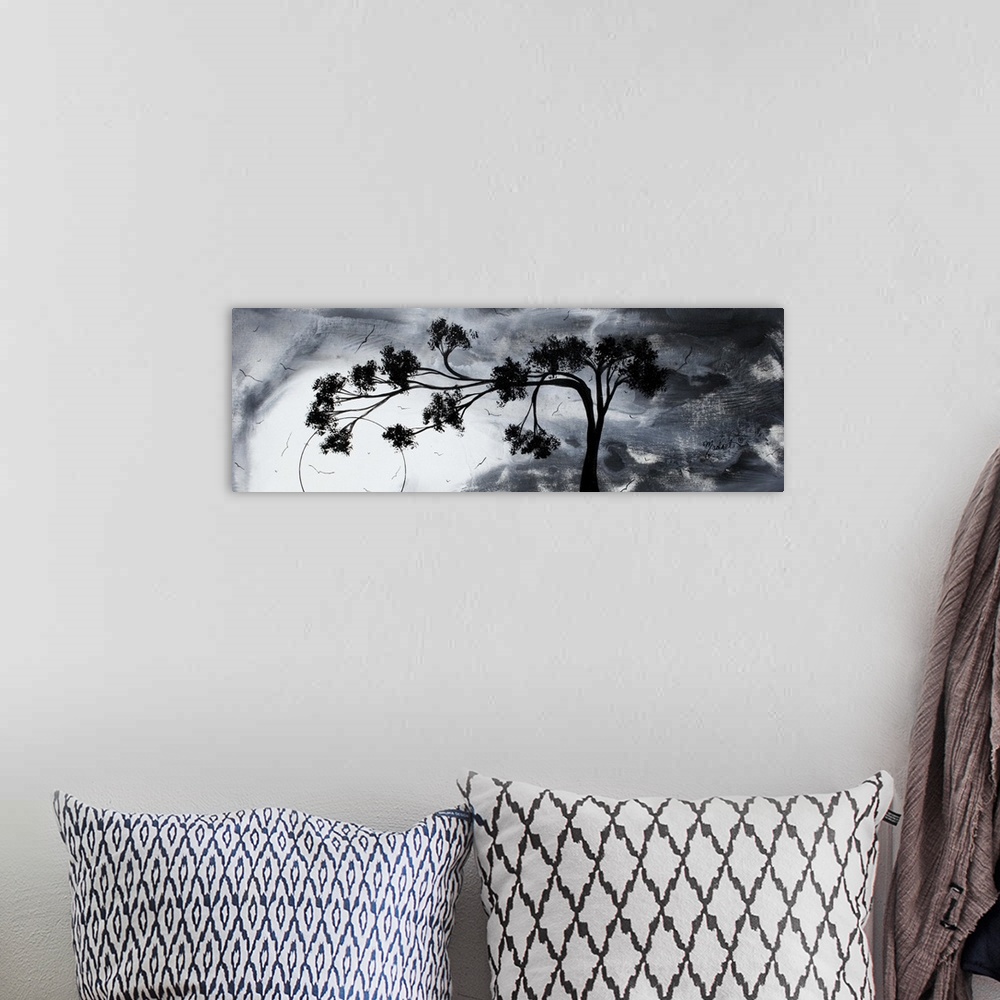 A bohemian room featuring Abstract artwork of a silhouetted tree that reaches far to the left against a gloomy sky with sev...