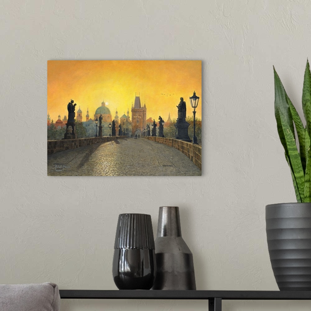 A modern room featuring Contemporary artwork of a view across a long old bridge lined with statues, toward a city filled ...