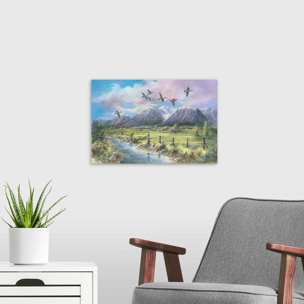 A modern room featuring Contemporary painting a mountainous valley and an old barn in the distance, with geese flying ove...