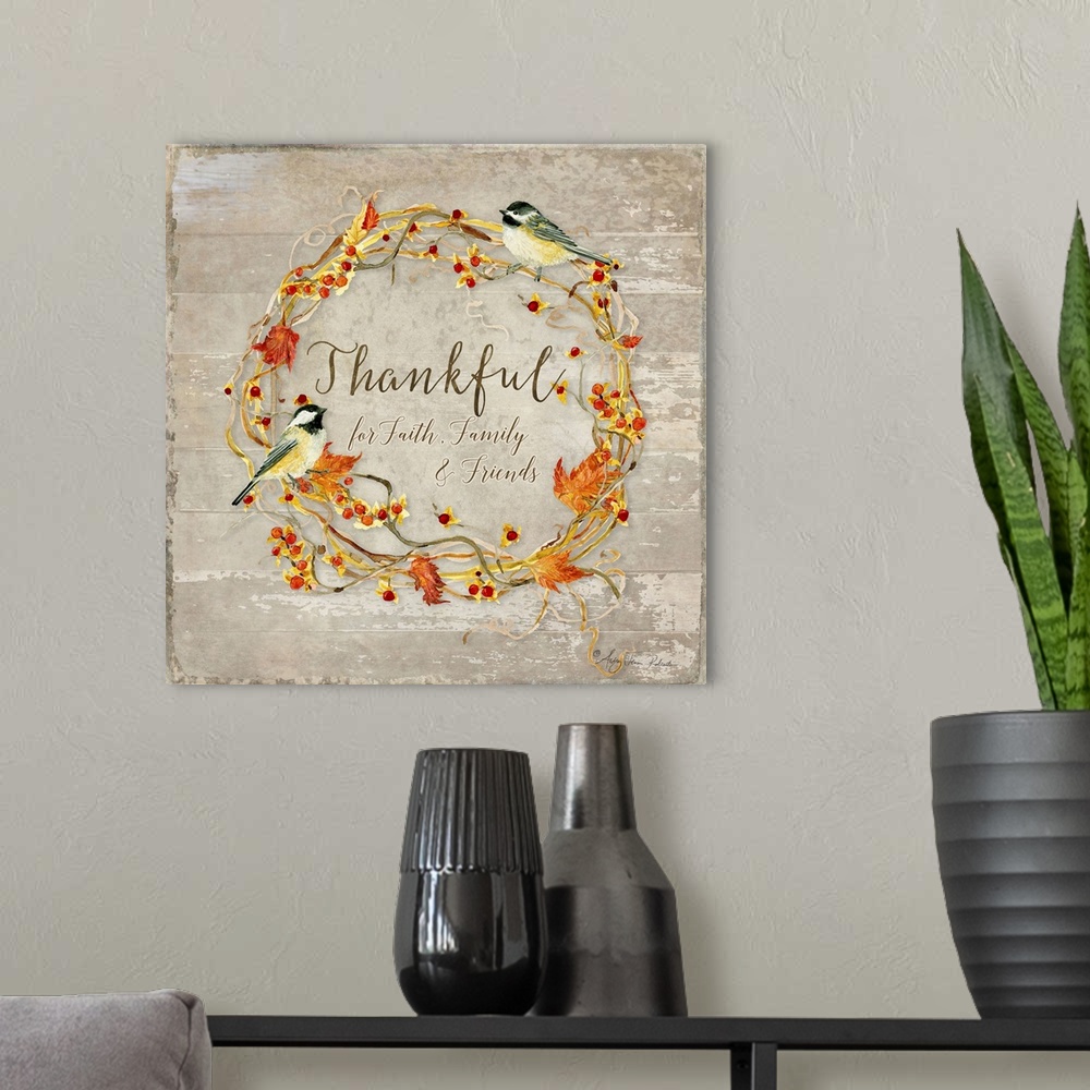 A modern room featuring Thanksgiving decor of a wreath made of leaves and berries with two chickadees.