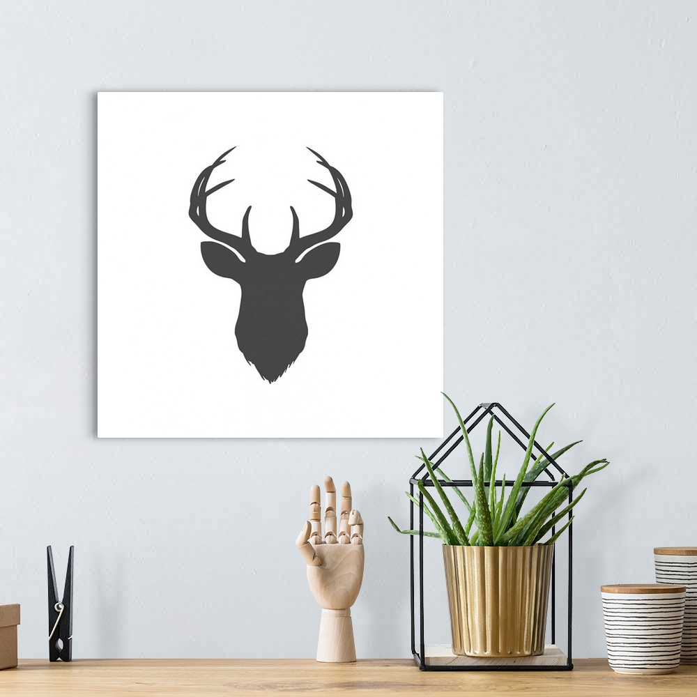 A bohemian room featuring A dark gray silhouette of a deer head and antlers against a white background.