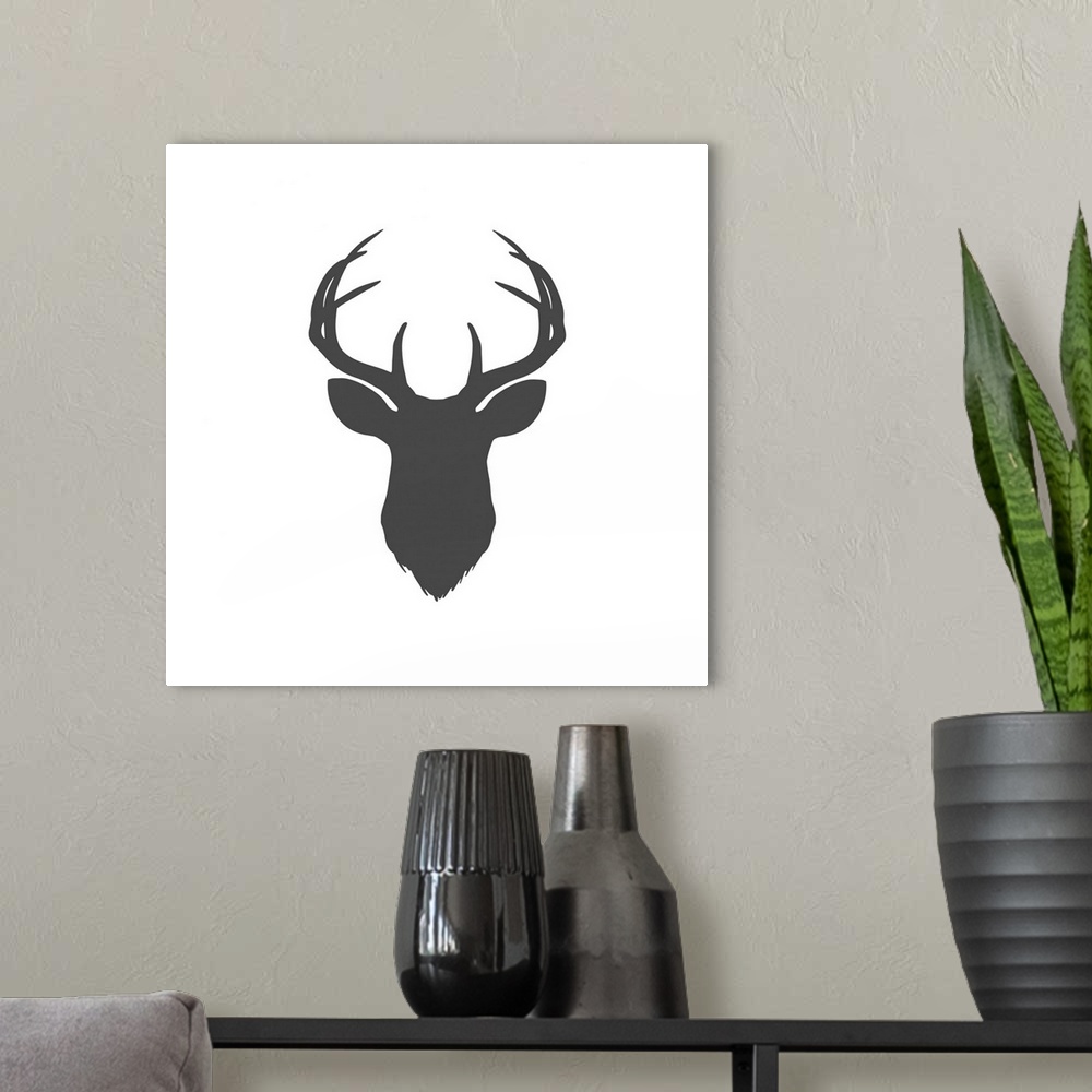 A modern room featuring A dark gray silhouette of a deer head and antlers against a white background.