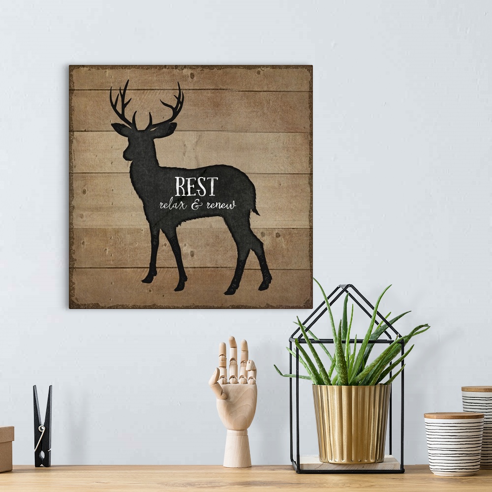 A bohemian room featuring Cabin decor of a deer silhouette on a wooden board background.