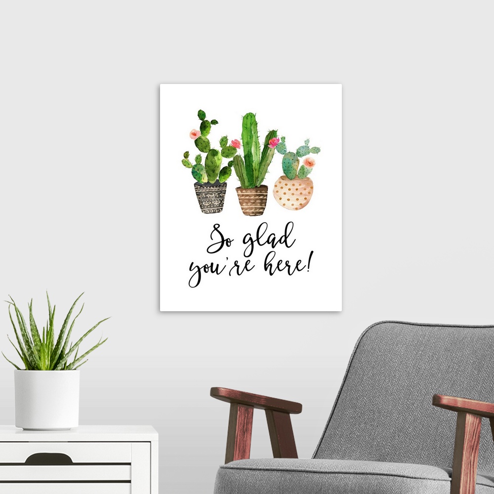 A modern room featuring This decor features watercolor cactus plants with the words, "So glad you're here!" underneath.