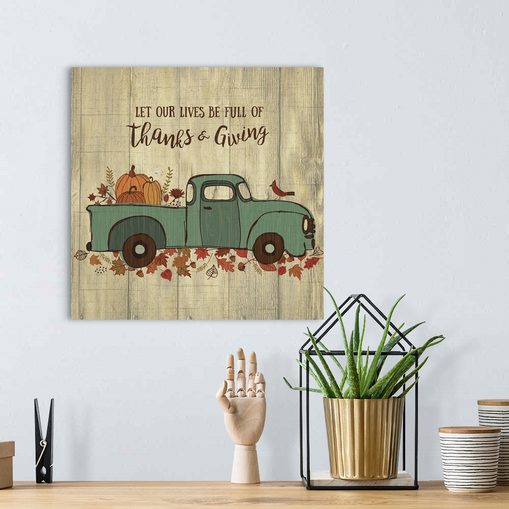 A bohemian room featuring Thanksgiving themed decor of a blue truck carrying pumpkins on a leafy trail.