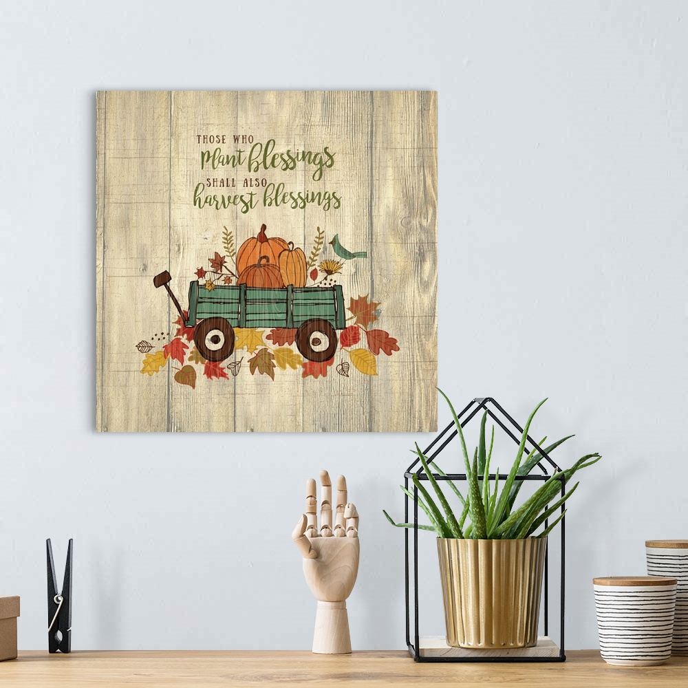A bohemian room featuring Thanksgiving themed decor of a wagon filled with pumpkins on a leafy trail.