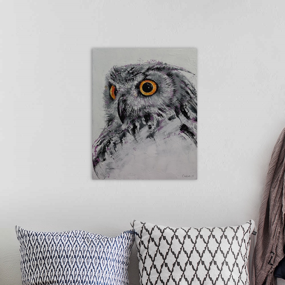 A bohemian room featuring A portrait of a gray owl with glaring orange eyes.