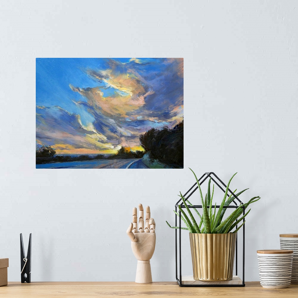 A bohemian room featuring Horizontal painting on large canvas of a road leading into the sunset, beneath a sky of swirling ...