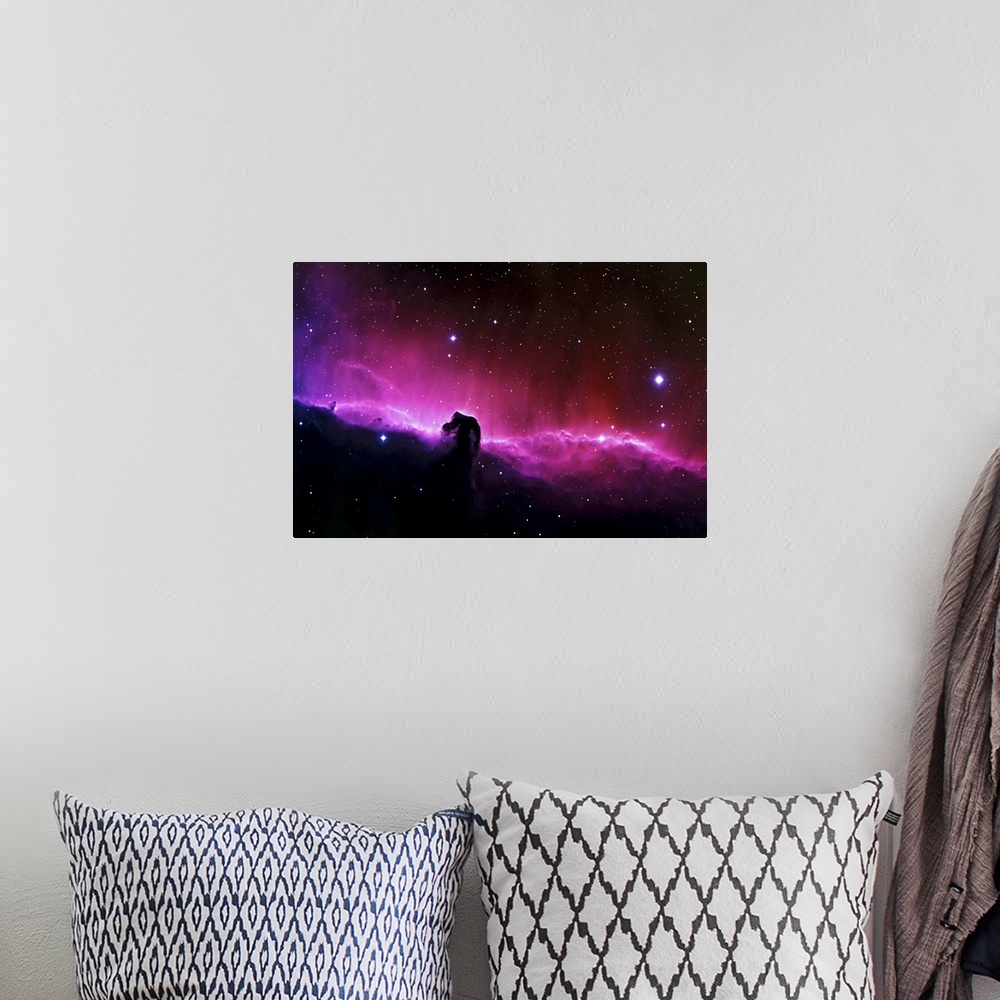 A bohemian room featuring Big wall art of a brightly colored nebula in the solar system with clouds that look like a horse'...