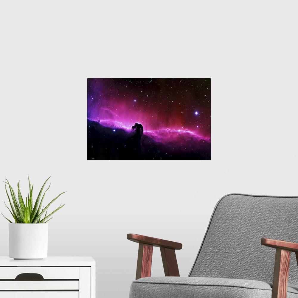 A modern room featuring Big wall art of a brightly colored nebula in the solar system with clouds that look like a horse'...