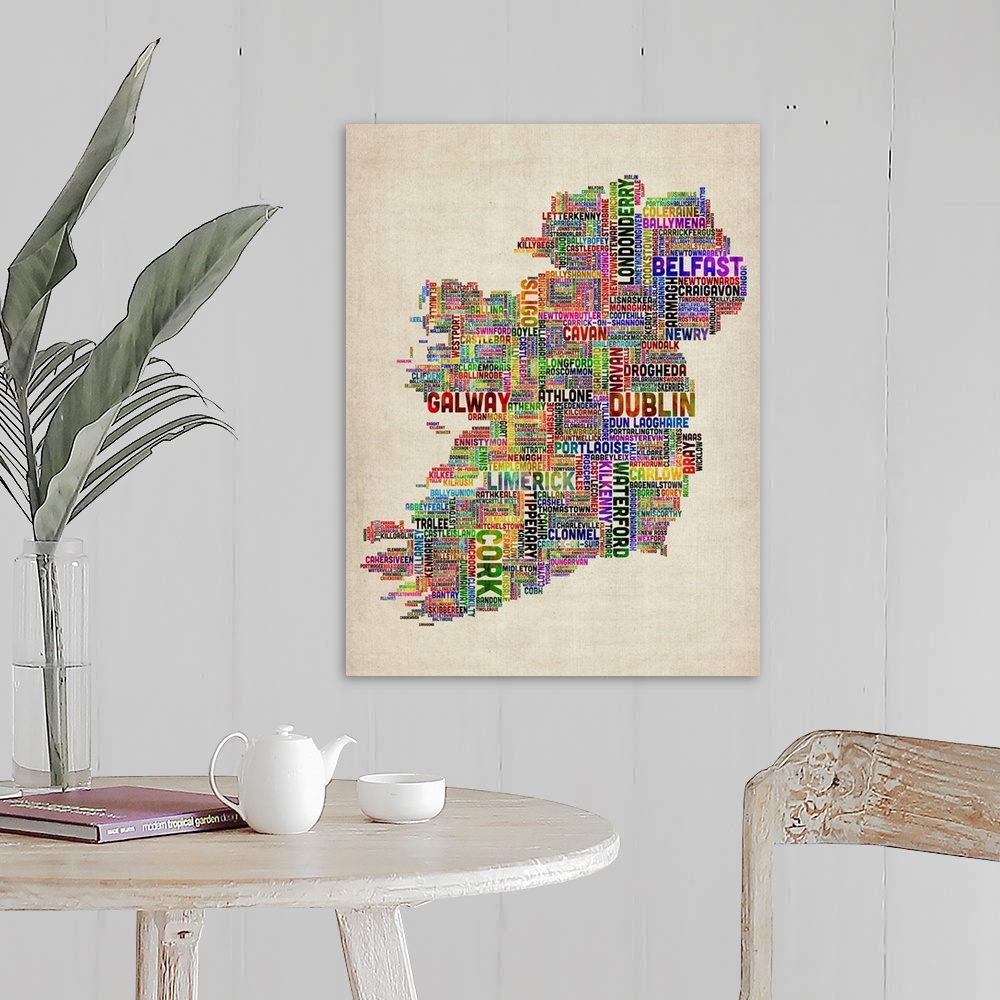 A farmhouse room featuring Vertical, big canvas art of Ireland, composed of city names in multiple, bright colors, on a parc...