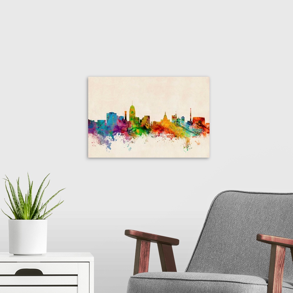 A modern room featuring Contemporary piece of artwork of the Lansing skyline made of colorful paint splashes.