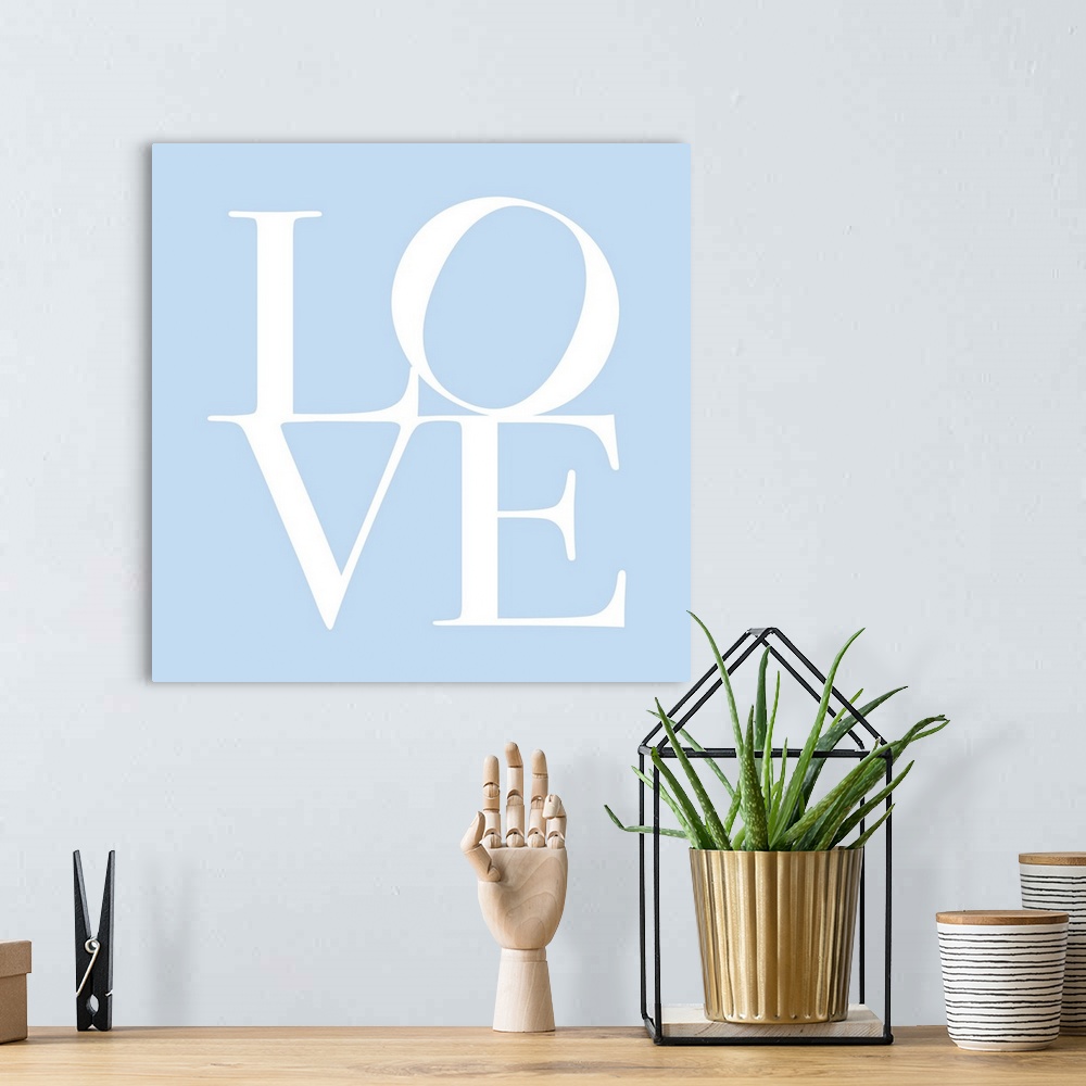 A bohemian room featuring LOVE, typography text art print and canvas print, with the word LOVE written against a baby blue ...