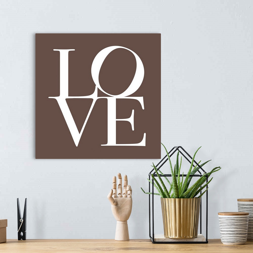 A bohemian room featuring The word LOVE is written in large white text against a taupe background.